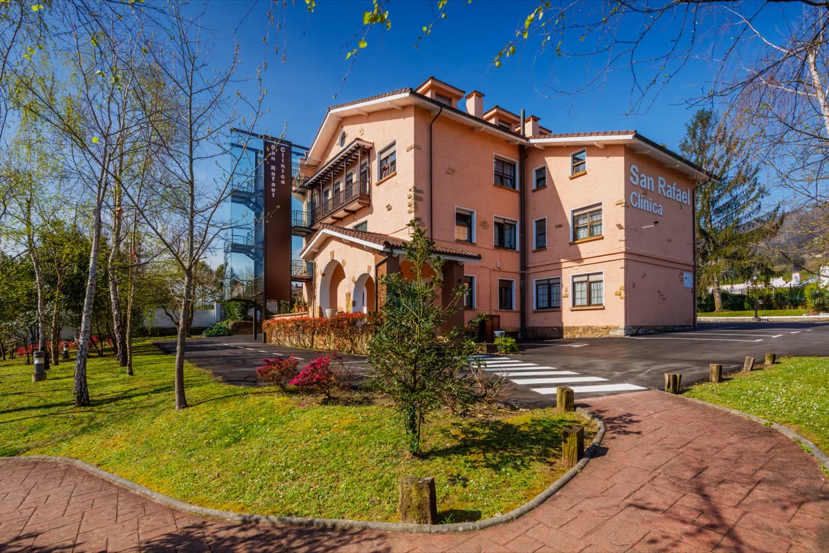 Fachada de la clínica con el rótulo San Rafael, el jardín delantero y el paseo de acceso